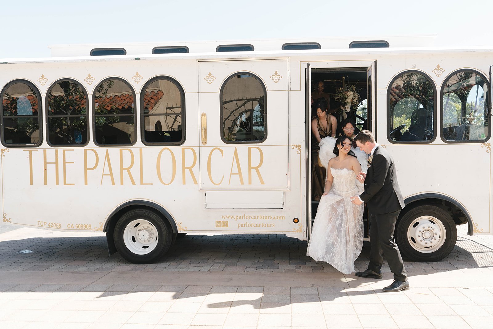 Newlyweds stepping out of The Parlor Car trolley after their wedding