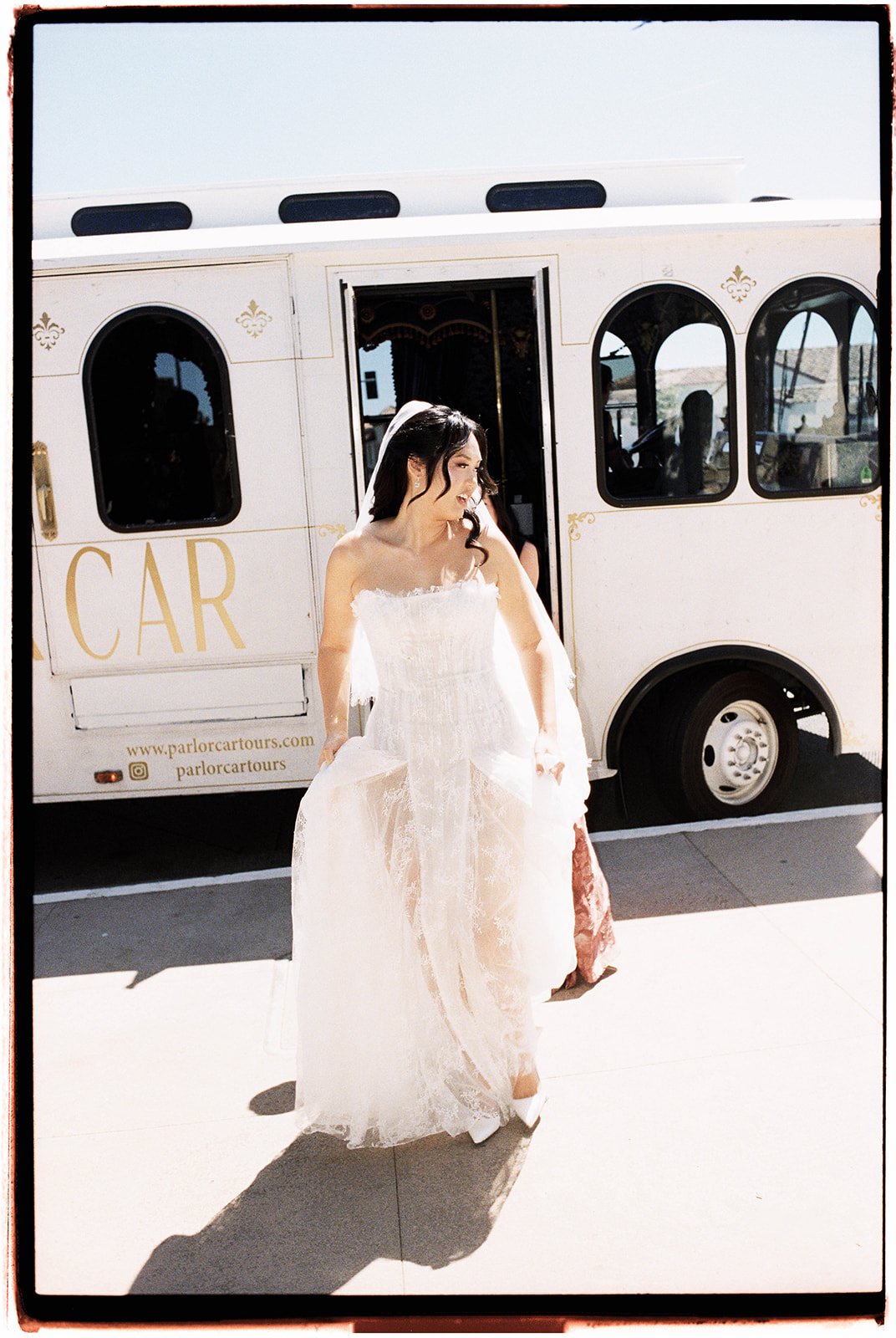 Bride standing beside The Parlor Car trolley before her wedding ride
