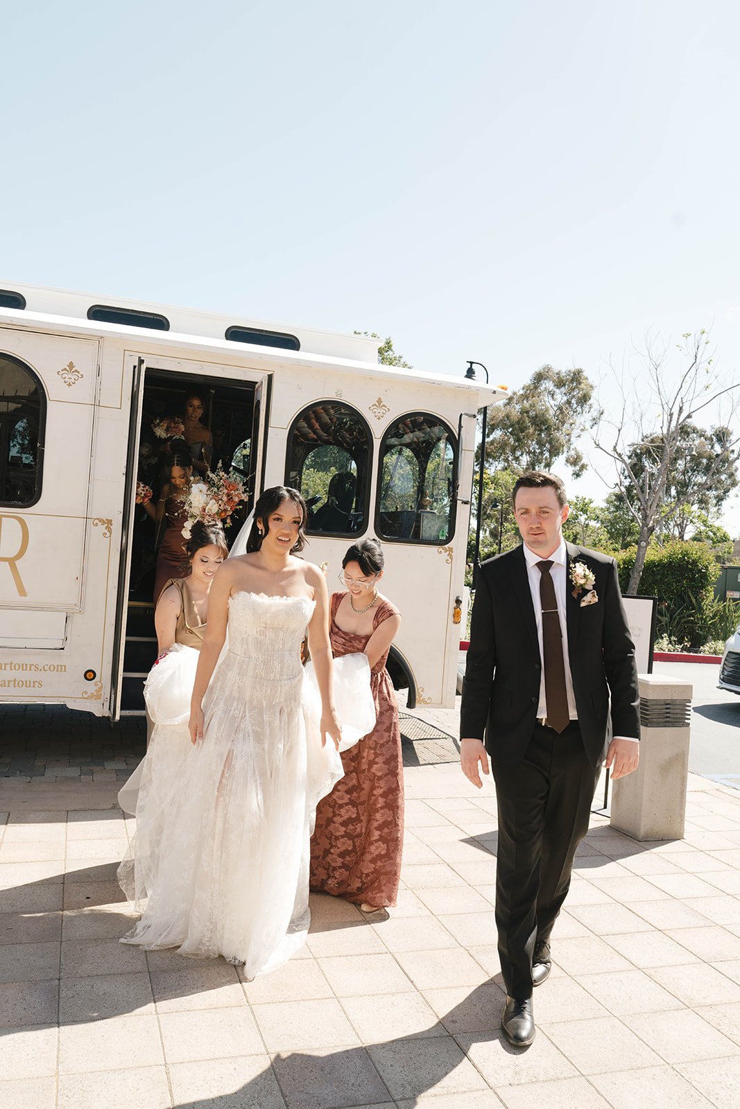 Bride and groom walking together in front of The Parlor Car trolley
